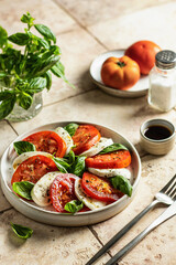 Plate of Healthy Classic Caprese Salad with Mozzarella Cheese, Tomatoes and Basil