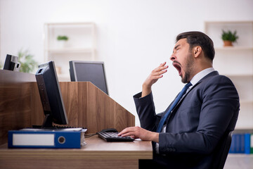 Naklejka premium Young male employee working in the office