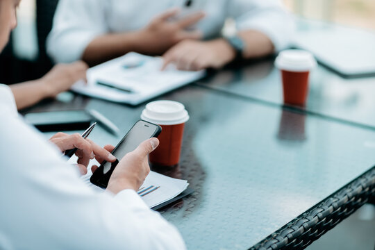 businessman using his smartphone to analyze a financial chart .