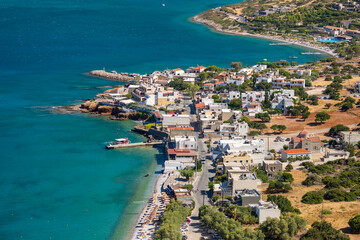 Fototapeta na wymiar Small Greek coastal village with beach and clear blue sea (Plaka, Elounda, Crete)