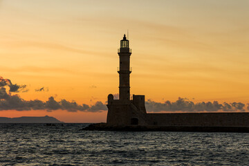 Sunset behind an ancient stone lighthouse (Veneitian Port, Chania, Crete)