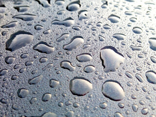 water droplets on the roof of a black car abstract background