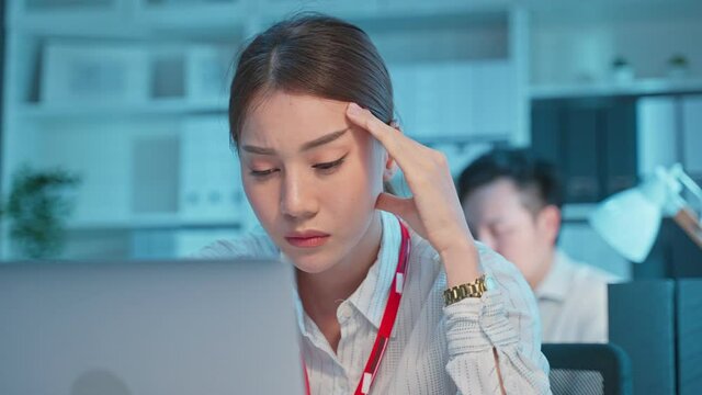 Exhausted Asian sick business woman worker working on table in office. 