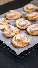 Homemade cottage cheese shortbread cookies shape rose on cooling rack. Dark background.