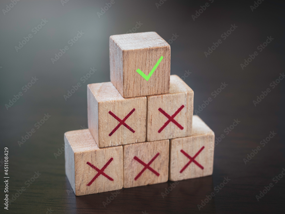Poster green check mark icon on top of red cross icons on wooden cube blocks, pyramid steps, on wood table 