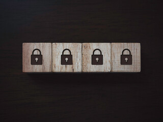 Privacy and personal data protection concept. Four lock icon on wooden blocks on dark wooden background, top view. Password security.