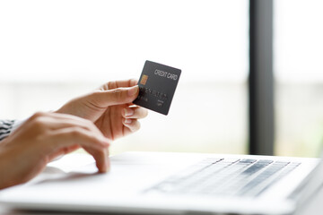 Woman holding smart phone and credit card for shopping online.Blank screen monitor for graphic display montage.Pay for goods by credit card through a smartphone .