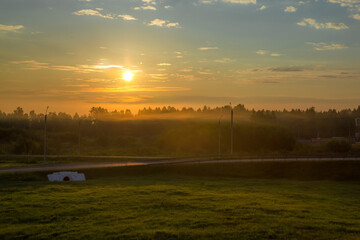 the rising sun peeps over the horizon and illuminates the beautiful summer landscape