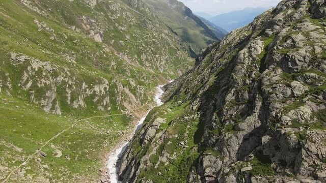 wide angle drone video of the beautiful mountains in northern Italy with a giant waterfall and river. near the dolomites in South Tyrol.