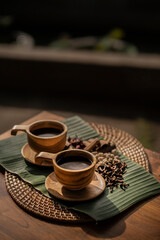 Rich aromatic coffee in rustic wooden cups on banana leaf - Aromatic morning ritual, perfect for cafe menus, food blogs, and wellness promotions