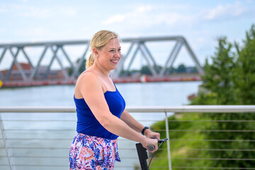 Happy vivacious middle-aged blond woman on a scooter