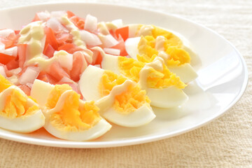 Boiled egg salad with tomatoes and onions on a white plate.  The concept of healthy and dietary food.

