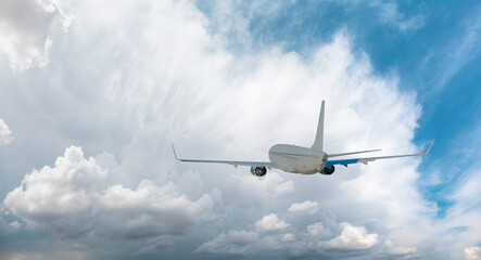 Obraz premium White passenger airplane over the stormy clouds - Travel by air transport