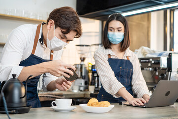 Asian Barista couple enjoy doing digital marketing in cafe restaurant