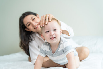 Portrait of Caucasian happy family smiling, look at camera in bedroom