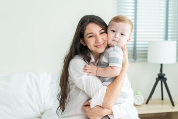 Portrait of Caucasian happy family smiling, look at camera in bedroom