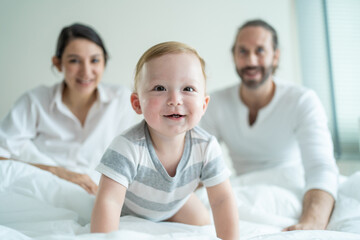 Fototapeta na wymiar Portrait of Caucasian happy family smiling, look at camera in bedroom.