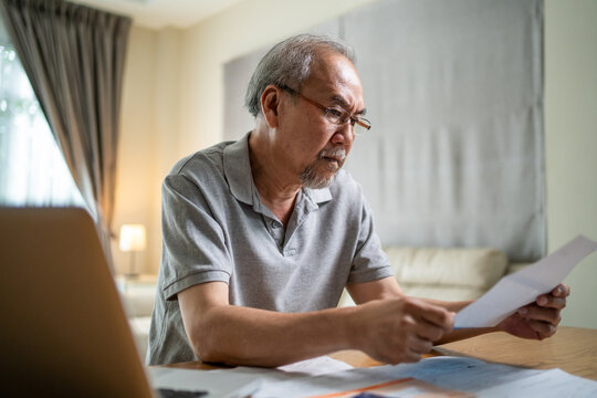Depressed Asian Senior male feeling worried about financial problem