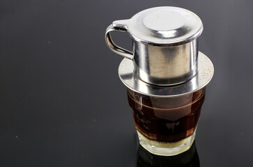Vietnamese Coffee with Condensed Milk in Glass Cups and Traditional Metal Coffee Maker Phin....