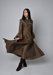 Naklejka premium Full length portrait of beautiful young asian woman with long hair wearing medieval fantasy gown costume. Graceful standing posing isolated on studio background.