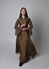 Fototapeta premium Full length portrait of beautiful young asian woman with long hair wearing medieval fantasy gown costume. Graceful standing posing isolated on studio background.