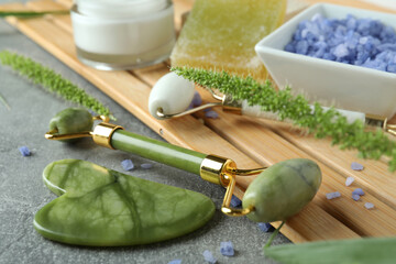 Skin care beauty concept with face rollers on gray textured background