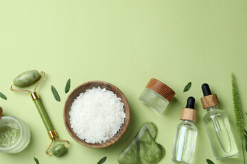 Skin care beauty concept with face roller on green background