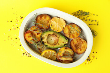 Bowl with tasty grilled peach on yellow background