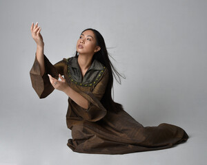 Full length  portrait of beautiful young asian woman with long hair wearing medieval fantasy gown...