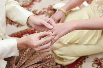 Close up of a man in love putting wedding ring on his woman finger. Marriage proposal engagement