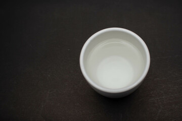 Fototapeta na wymiar White ceramic glass on black table background.