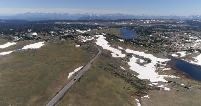 Cars going down on a curvy road in Beartooth Mountains near Yellowstone National Park. Aerial view