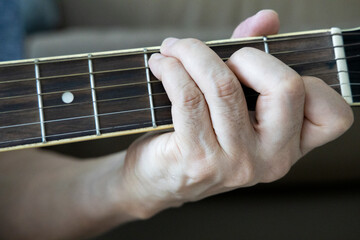 hand holding guitar chord for playing