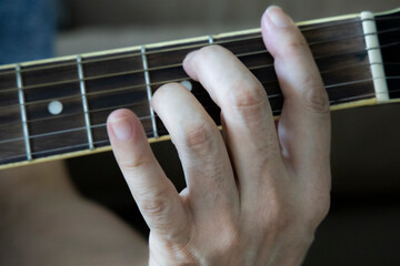 hand holding guitar chord for playing