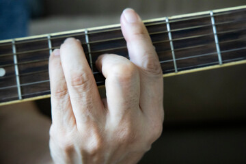 hand holding guitar chord for playing