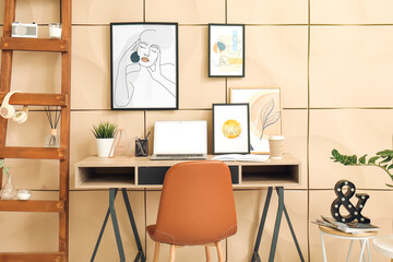 Interior of stylish room with modern workplace and pictures