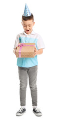 Surprised little boy with present on white background
