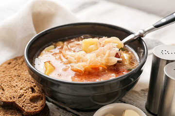 Bowl with tasty sauerkraut soup on table, closeup