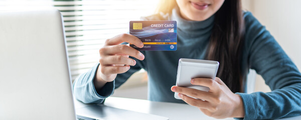 Hand of woman holding phone to pay online credit card