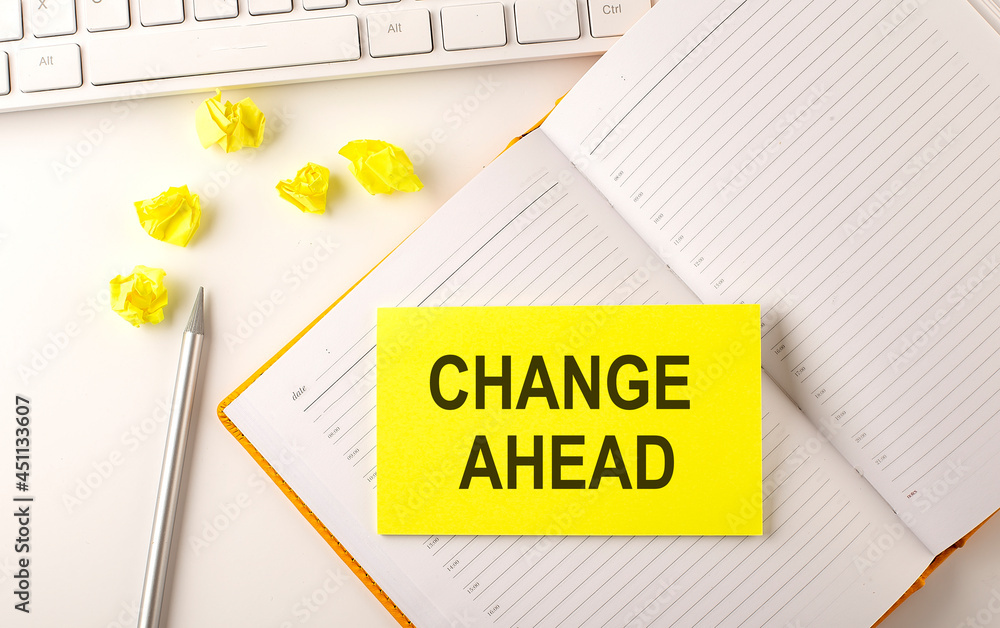 Poster change ahead text on sticker on the diary with keyboard and pencil