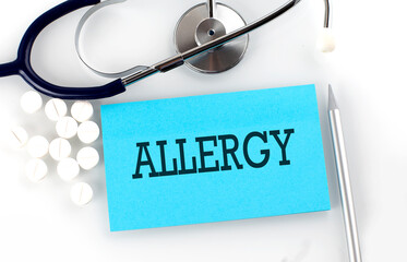 Text ALLERGY on a table with a stethoscope,pills and pen, medical concept.