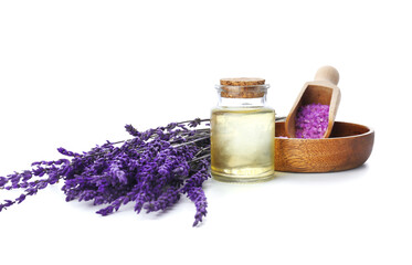 Fototapeta na wymiar Bottle of lavender essential oil, sea salt and flowers on white background