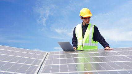 Asian engineer for solar panel inspection roof construction. Engineer worker installing solar panels outdoors. blue sky with white, soft clouds