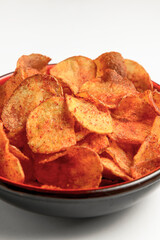 Hot spicy potato chips bowl isolated on white, in red bowl. Fast food, junk food concept, beer snack