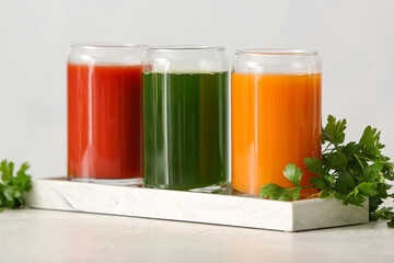 Glasses with healthy juice on light background