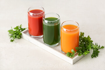 Glasses with healthy juice on light background
