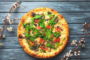 Rustic tasty pizza with meat, mushrooms, tomatoes and basil. Over wooden table, photo in dark tones.
