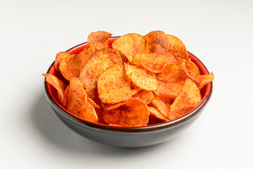 Hot spicy potato chips bowl isolated on white, in red bowl. Fast food, junk food concept, beer snack