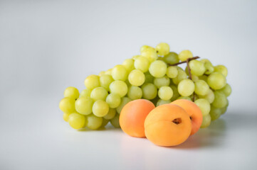 bunch of ripe green grapes and fresh abrekos on isolated white background