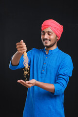 Naklejka premium Indian farmer holding wheat in his hand and smiling.